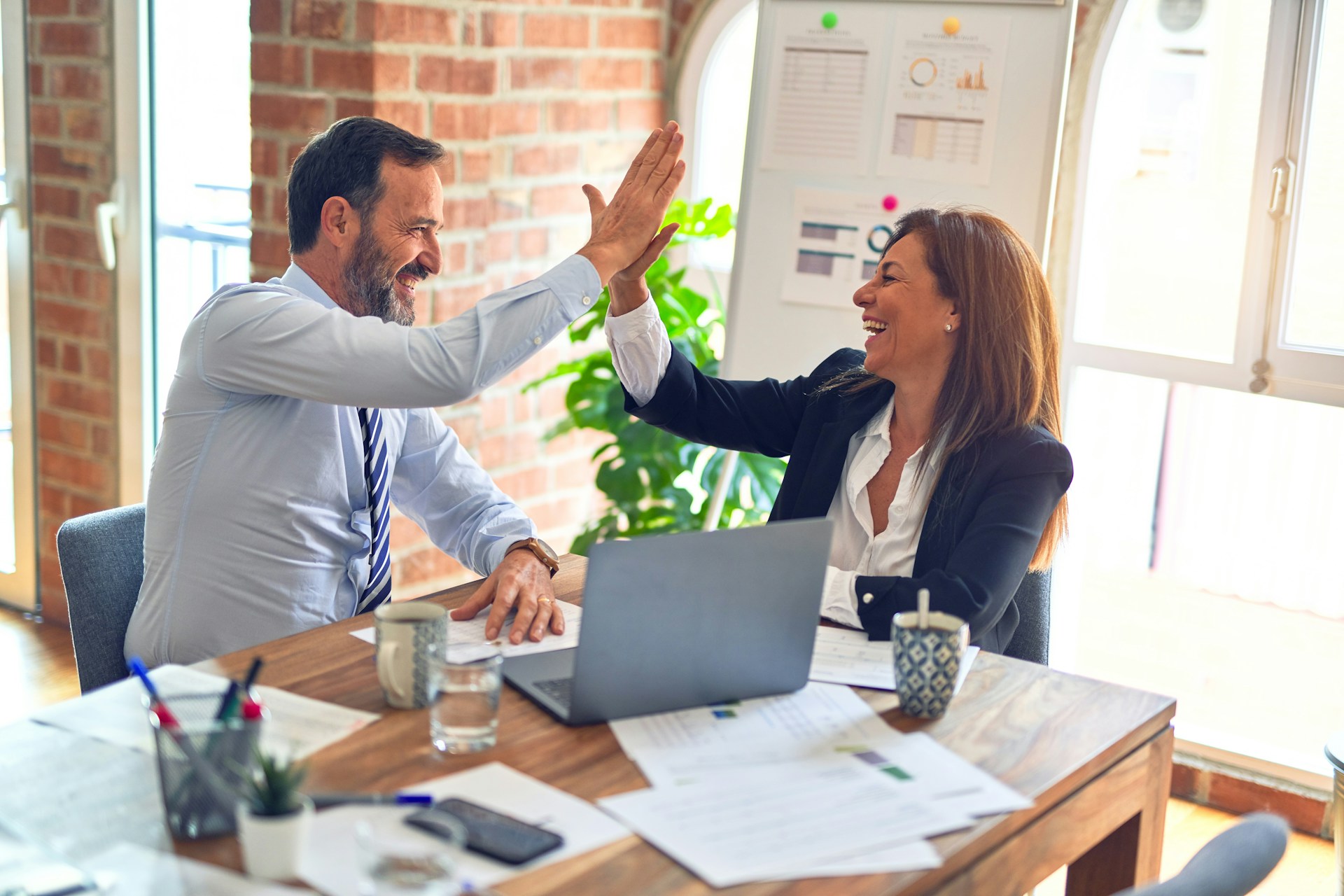 Twee professionals vieren een geslaagde samenwerking